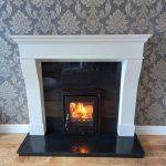 Roaring Fireplaces Installations wood burning stove with white mantlepiece